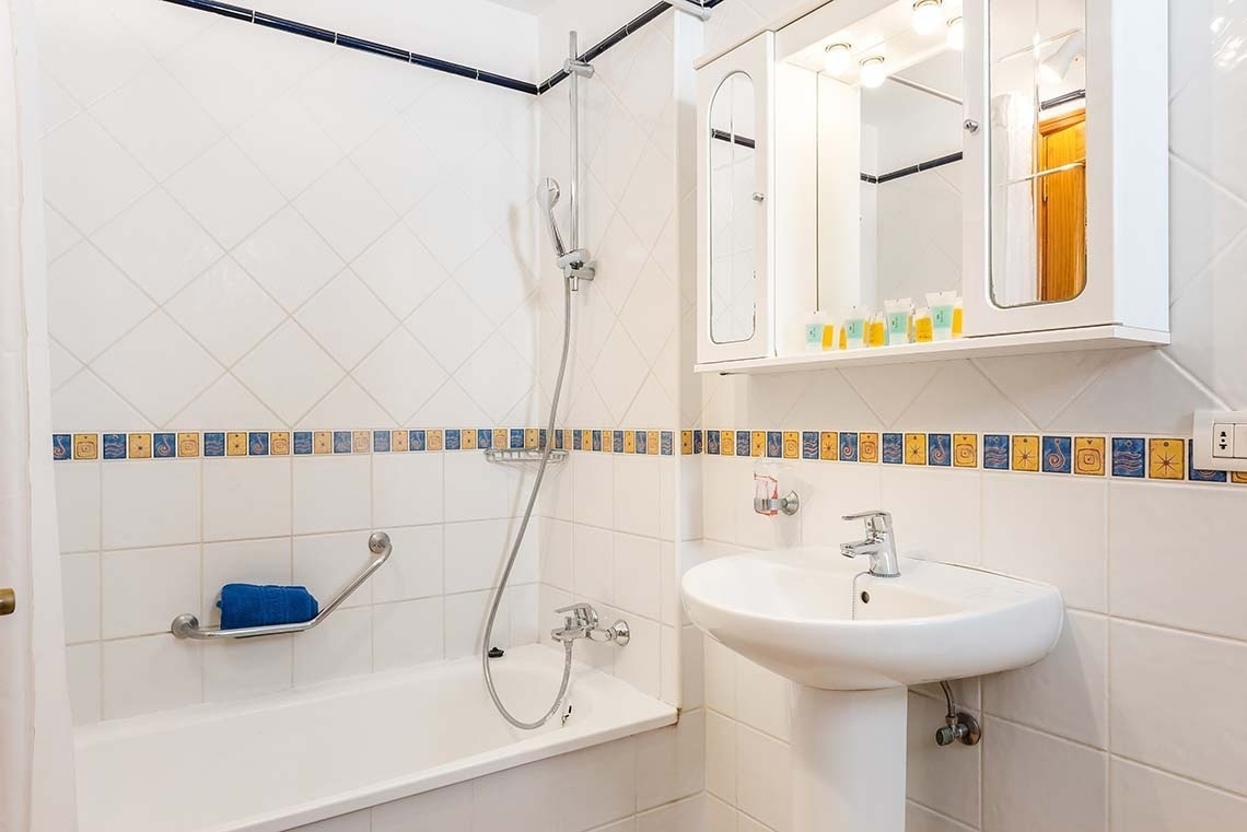 a bathroom with a bathtub sink and mirror