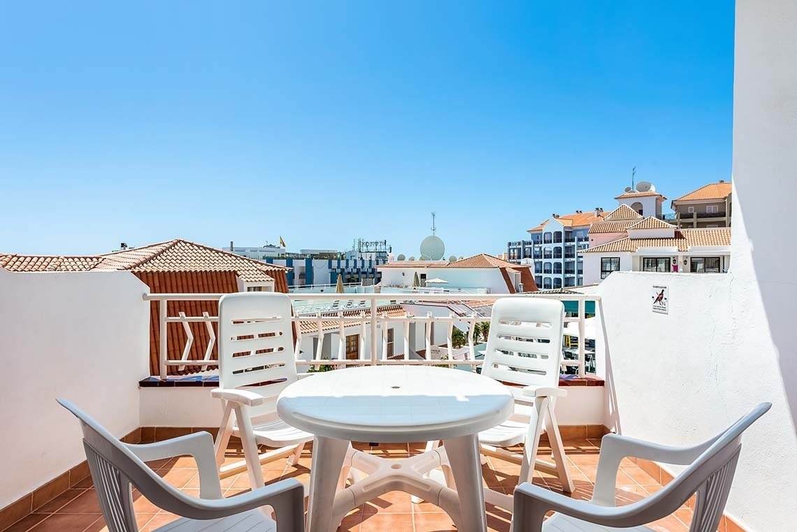 un balcón con una mesa y sillas y un letrero que dice 