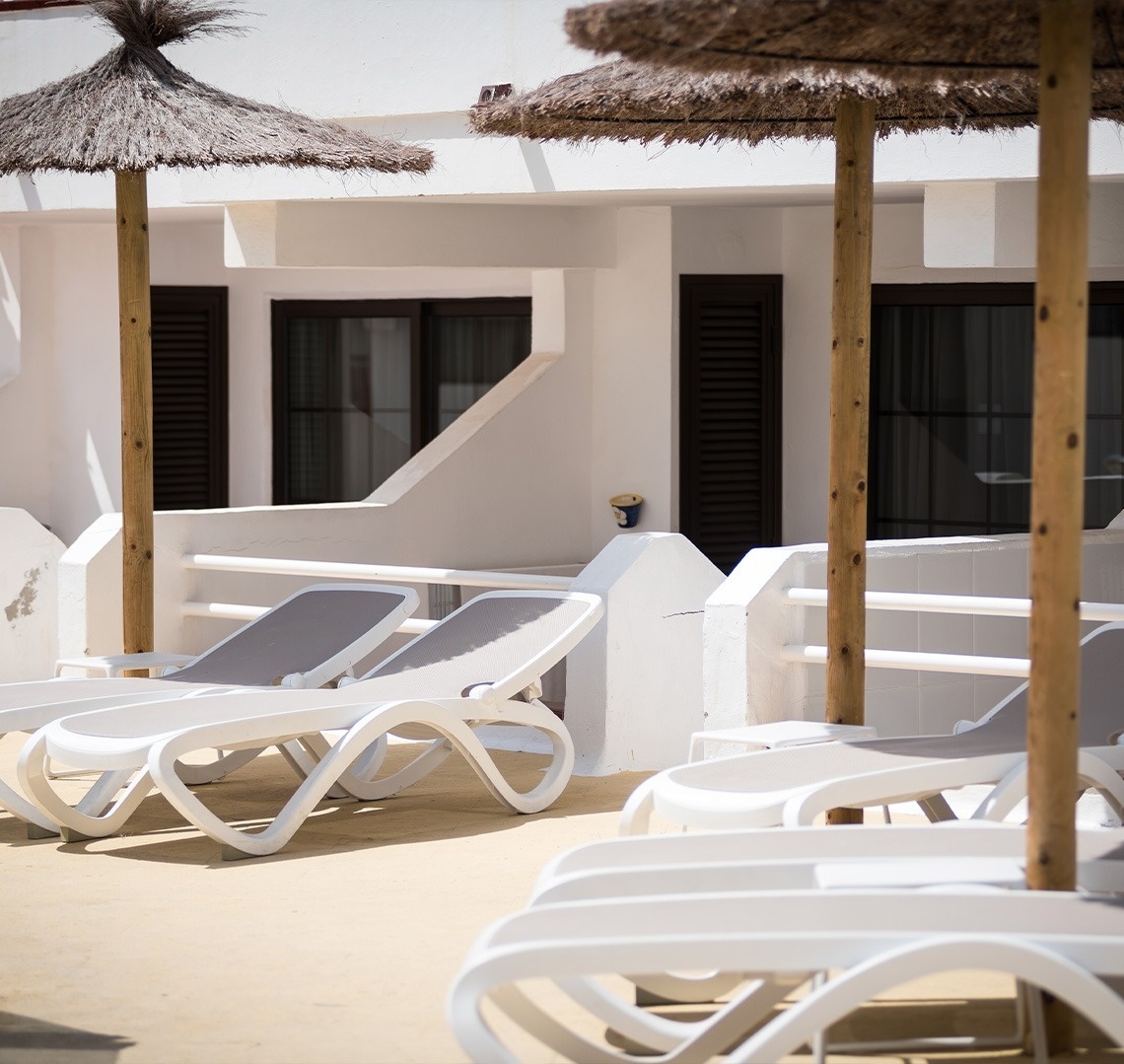 a large swimming pool in front of a white house