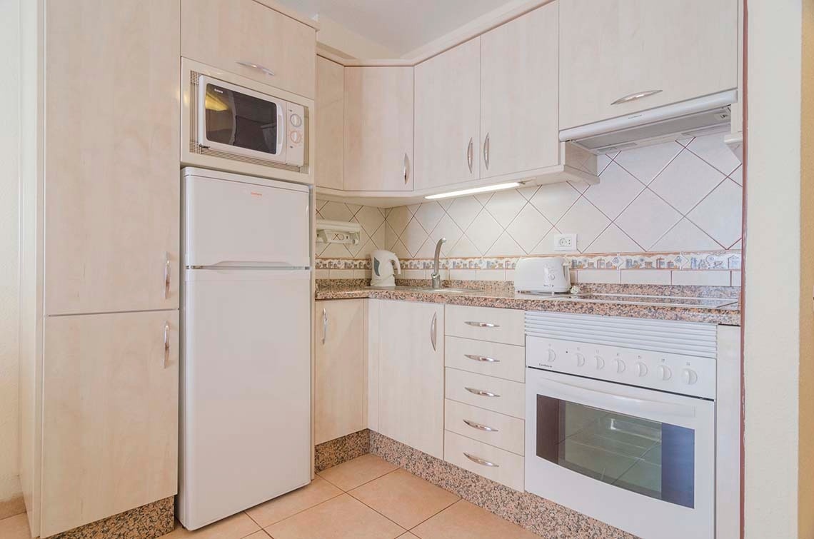 a kitchen with white cabinets and a white refrigerator