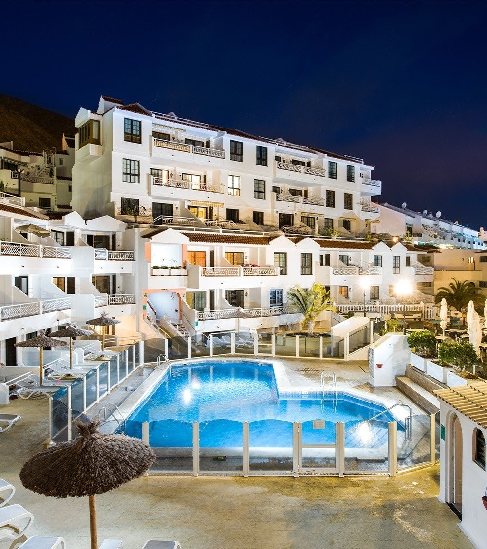 un hamac est assis à côté d' une piscine au coucher du soleil