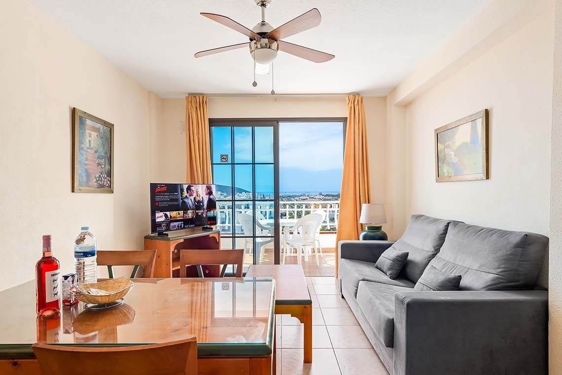 a living room with a sliding glass door and a ceiling fan
