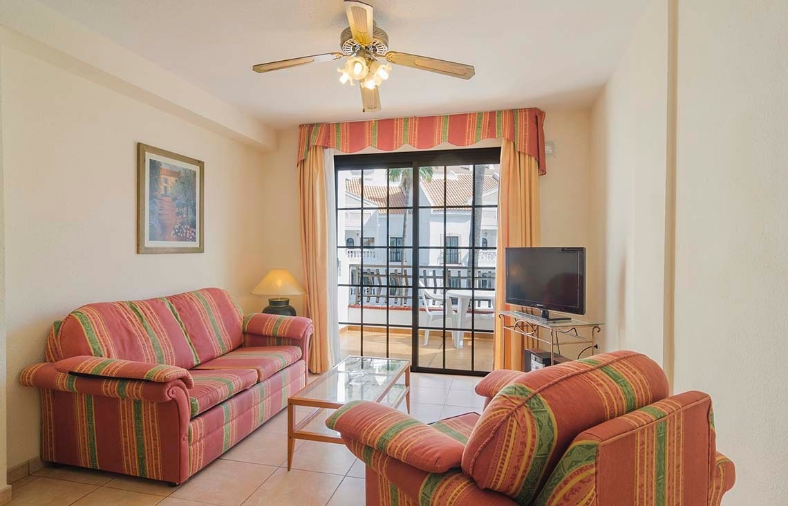 a living room with a sliding glass door and a ceiling fan