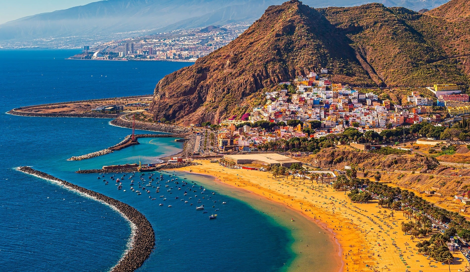 an aerial view of a beach filled with people and umbrellas