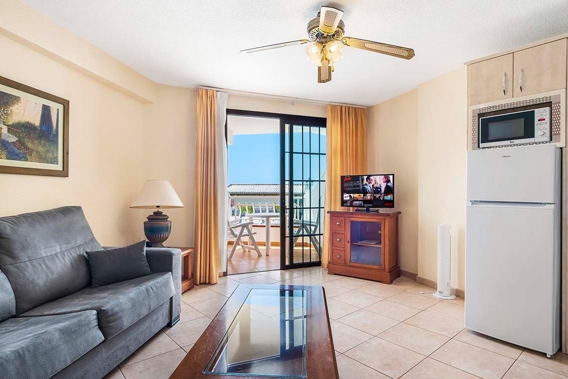 a living room with a sliding glass door leading to a balcony