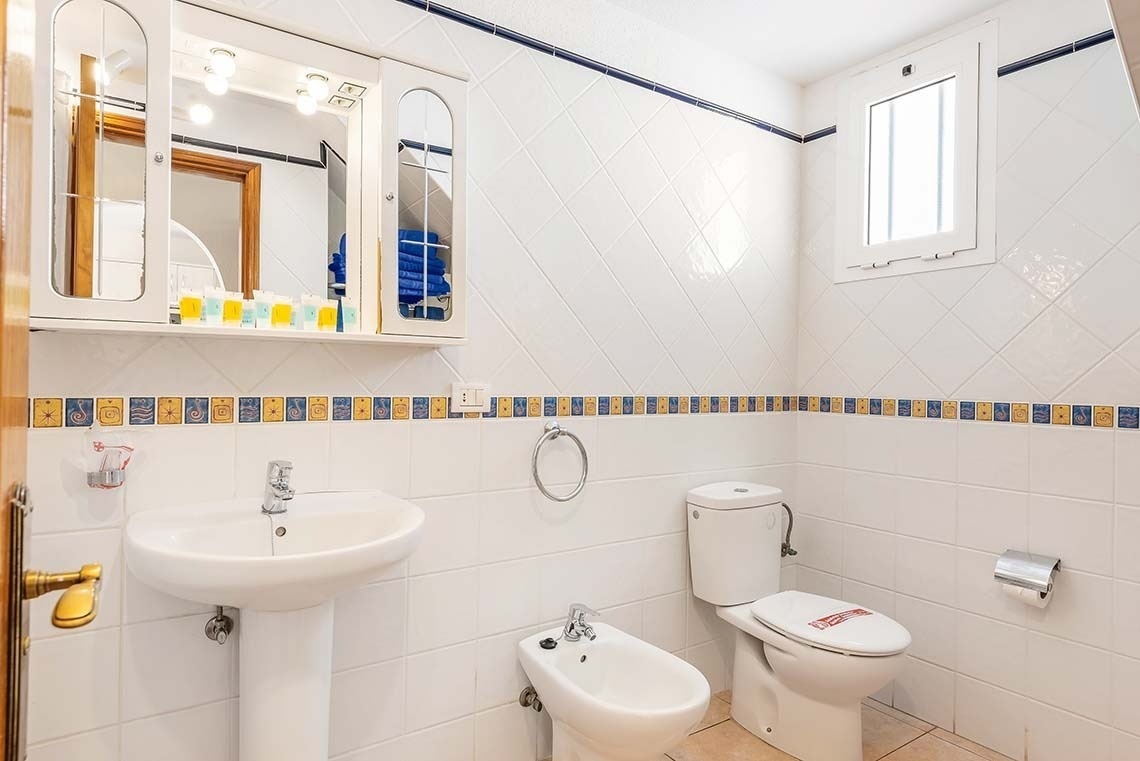 a bathroom with a toilet a sink and a mirror