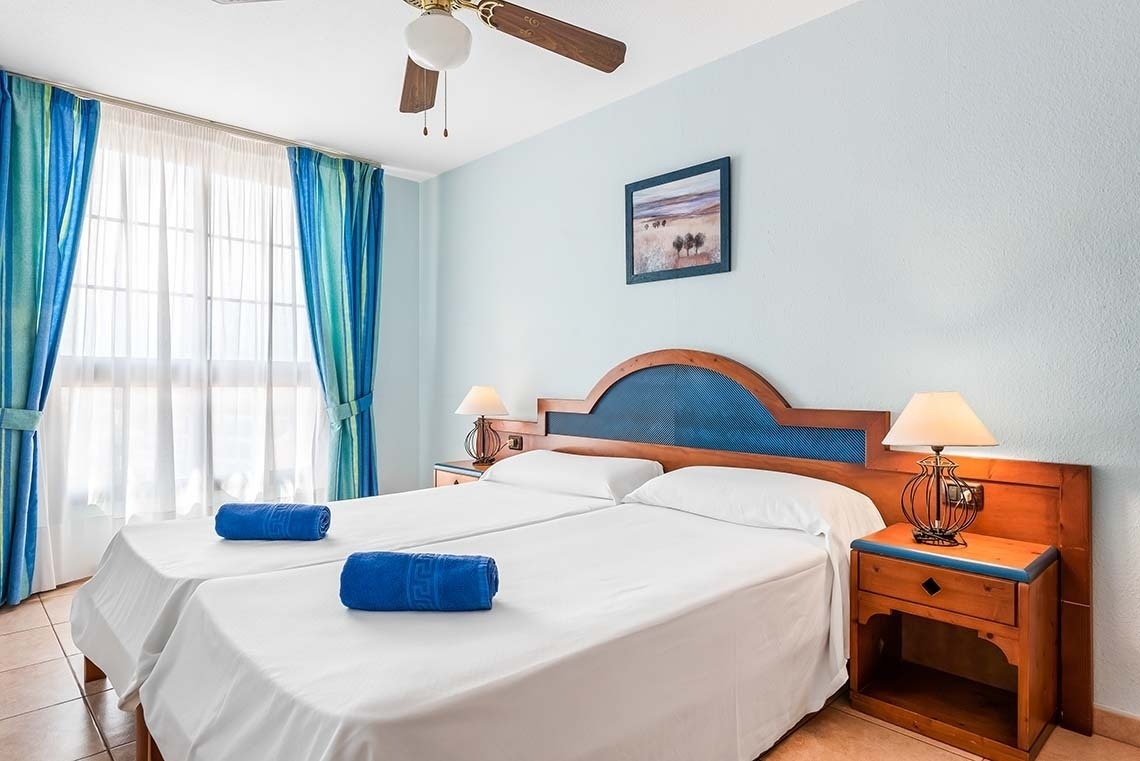 a hotel room with two beds and a ceiling fan