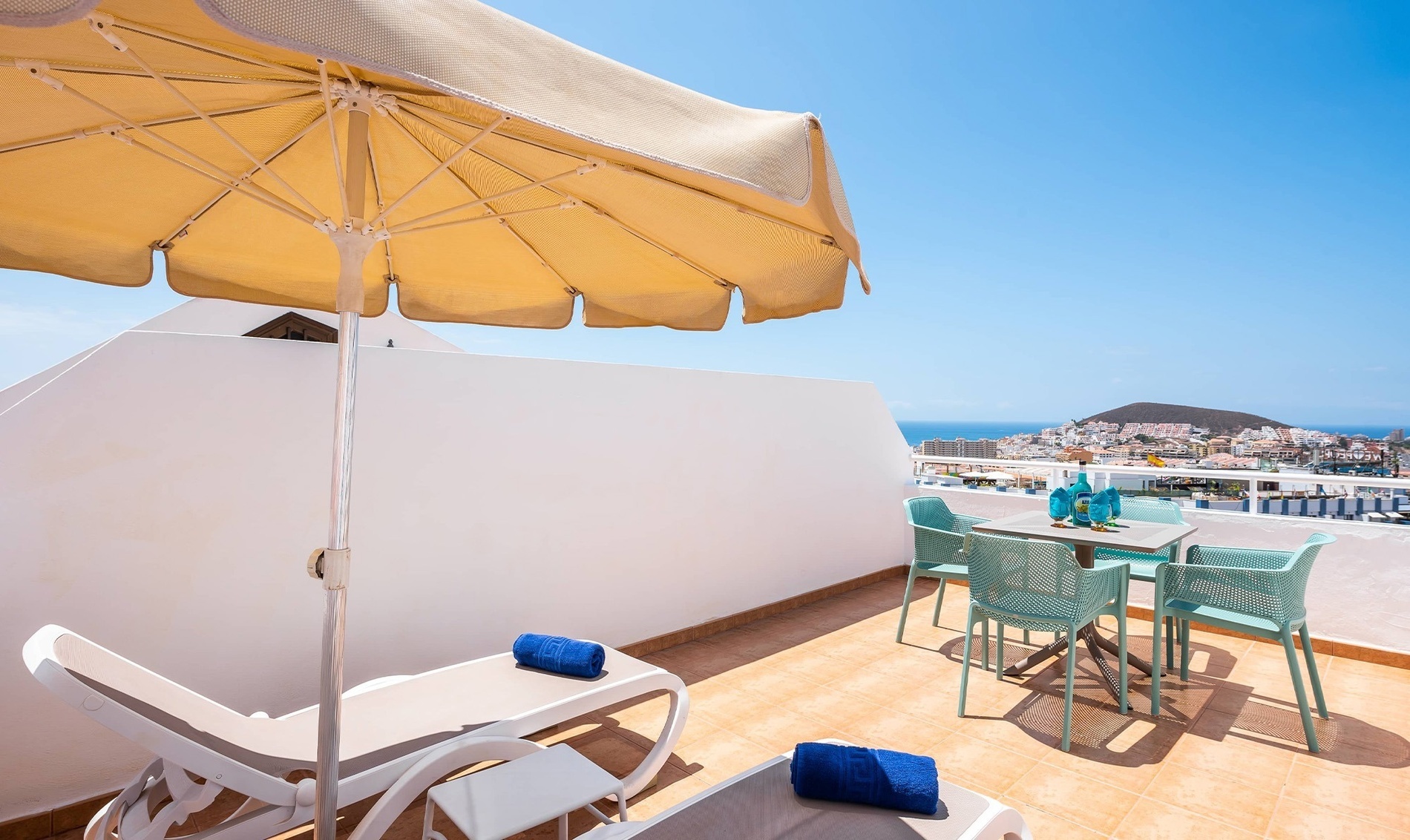 a patio with a canopy bed and lounge chairs