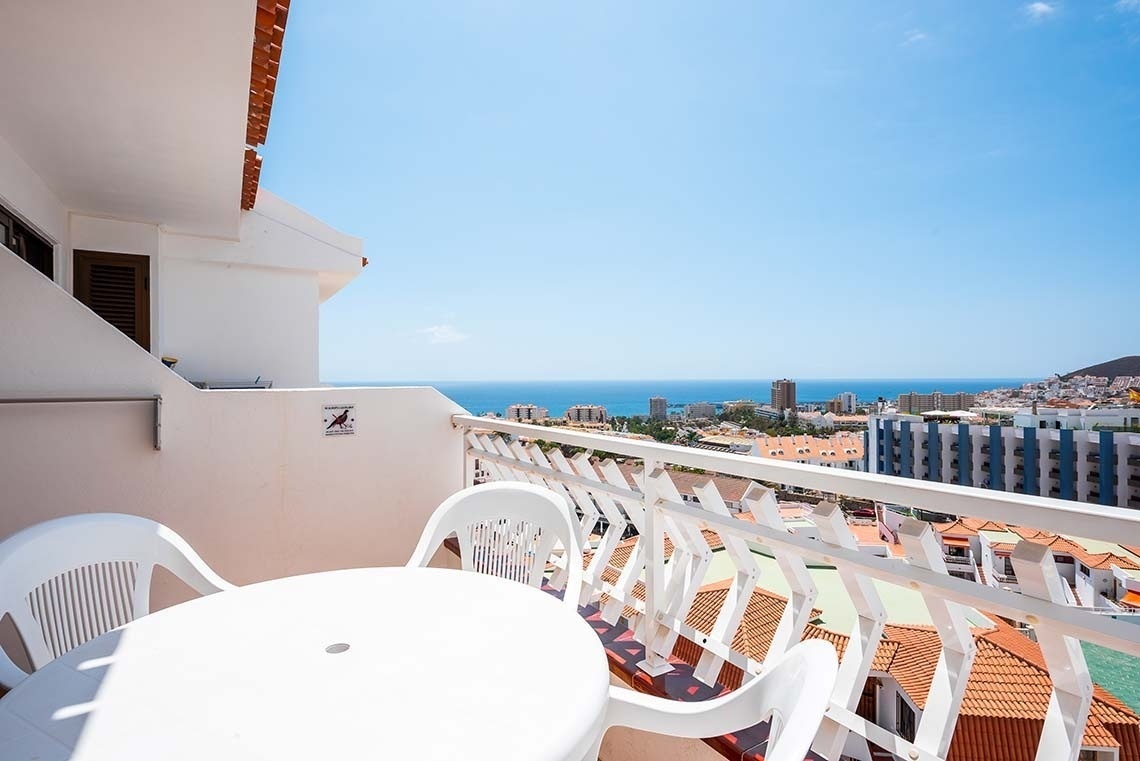 a balcony with a table and chairs and a sign that says no birds