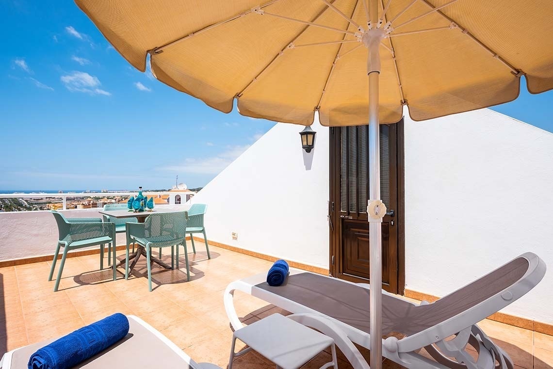 a patio with a table and chairs under an umbrella