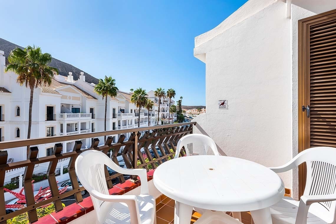 a balcony with a table and chairs and a sign that says no birds