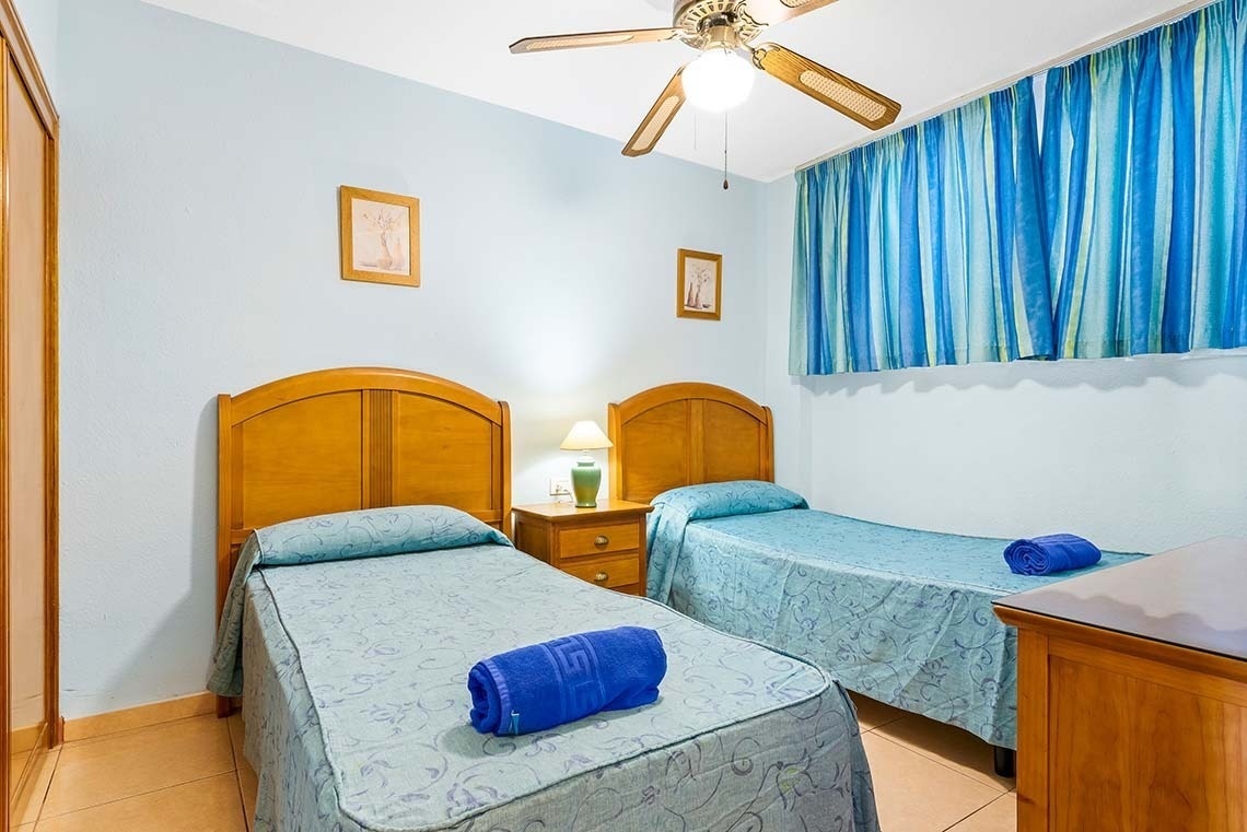 a bedroom with two beds and a ceiling fan