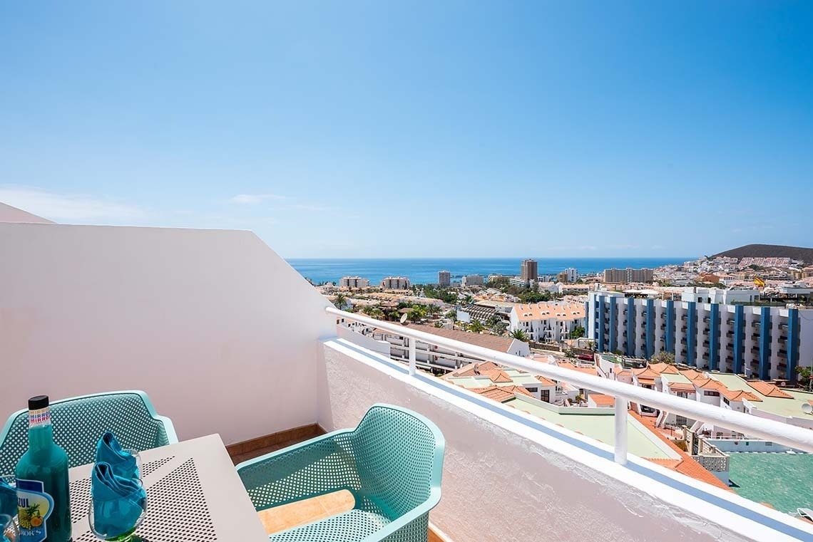 un balcón con una mesa y sillas y una botella de coca cola