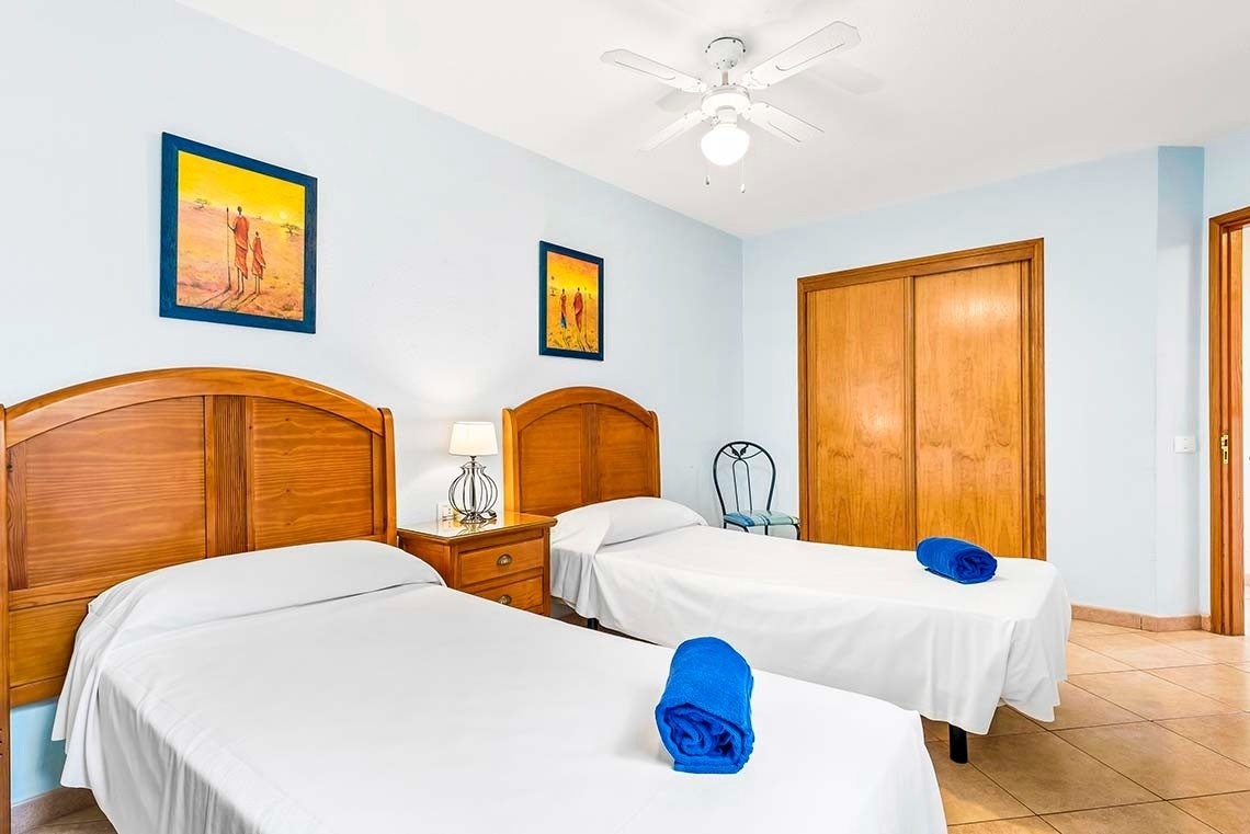 a bedroom with two twin beds and a ceiling fan