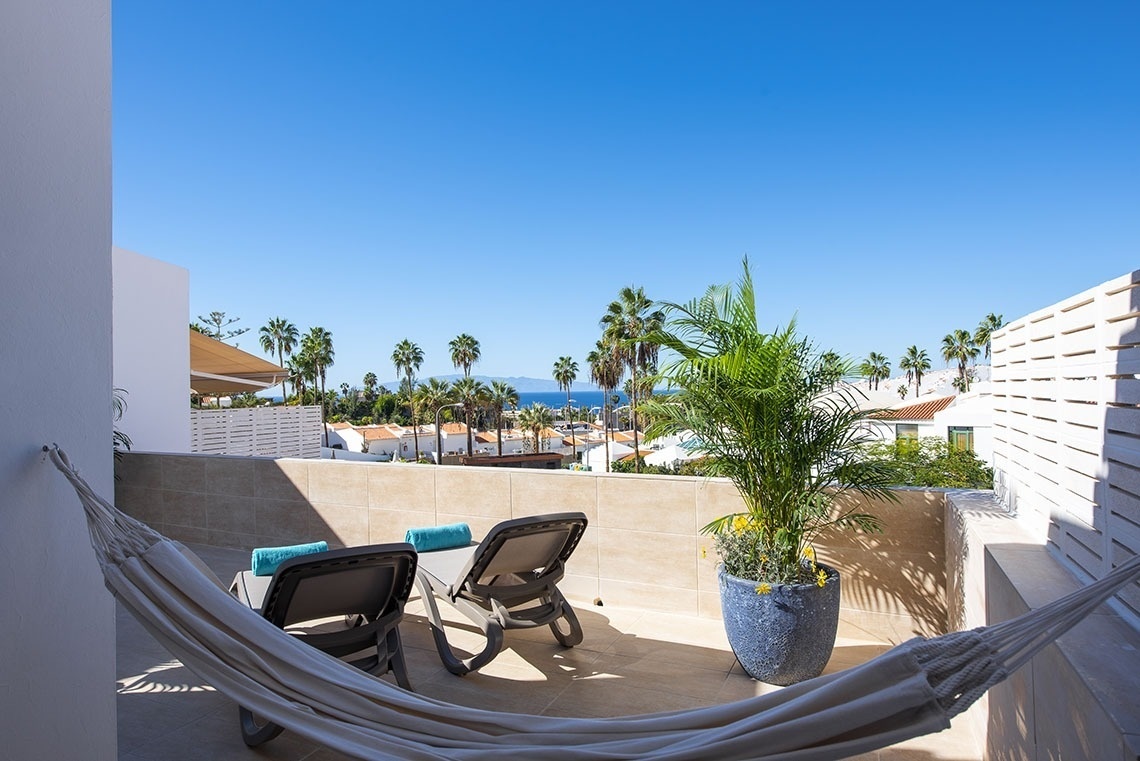 a hammock on a balcony overlooking the ocean