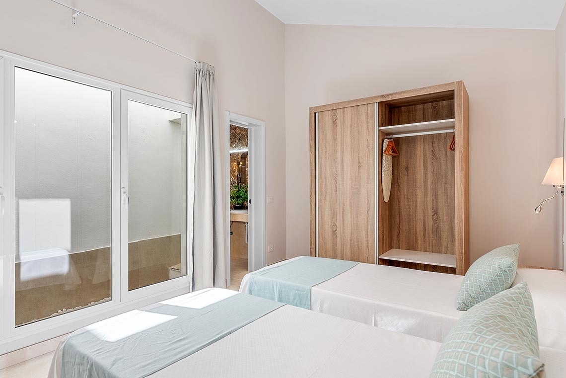 a bedroom with two beds and a sliding glass door