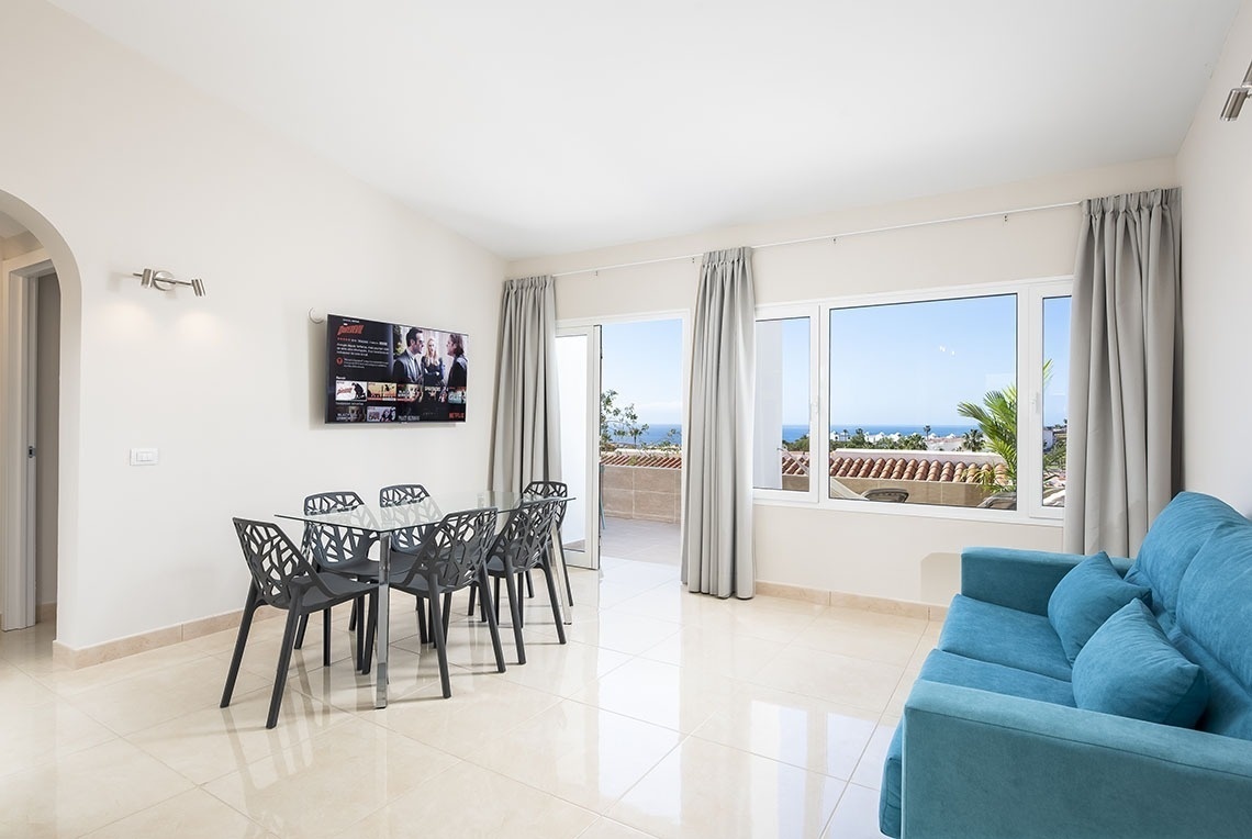 a living room with a blue couch and a netflix tv on the wall
