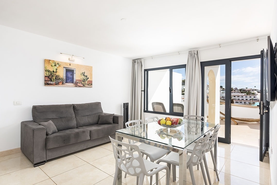 a living room with a couch and a dining table