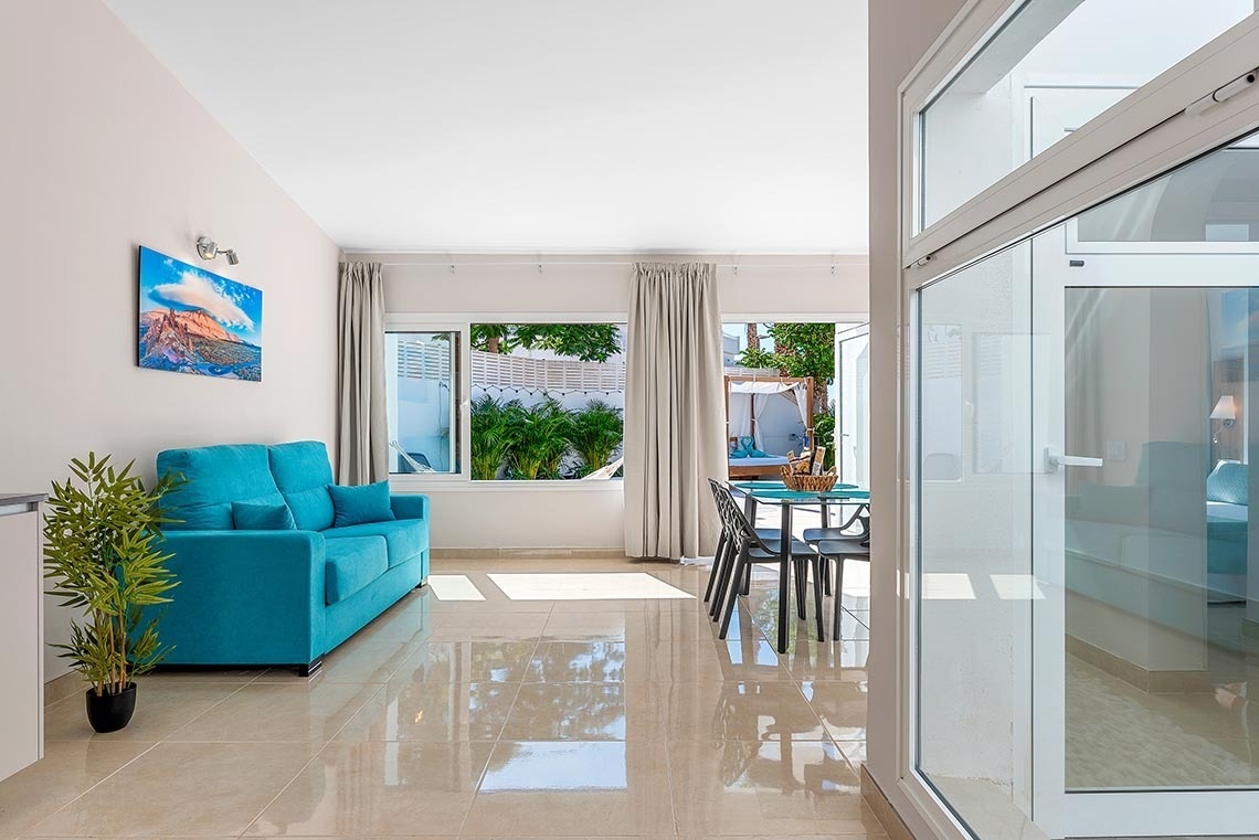 a living room with a blue couch and a painting on the wall