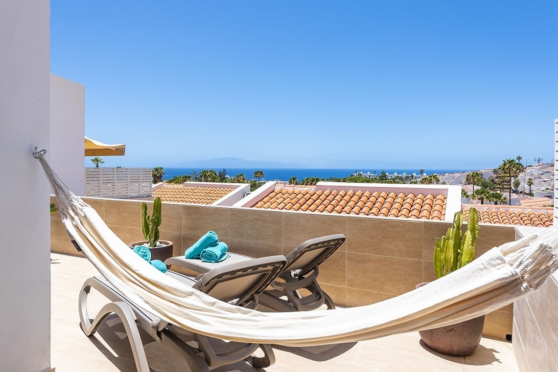 a hammock on a balcony overlooking the ocean