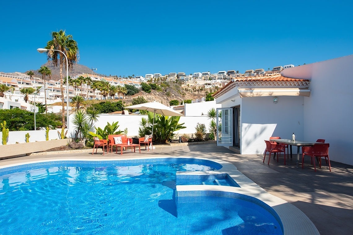 a swimming pool with a table and chairs around it