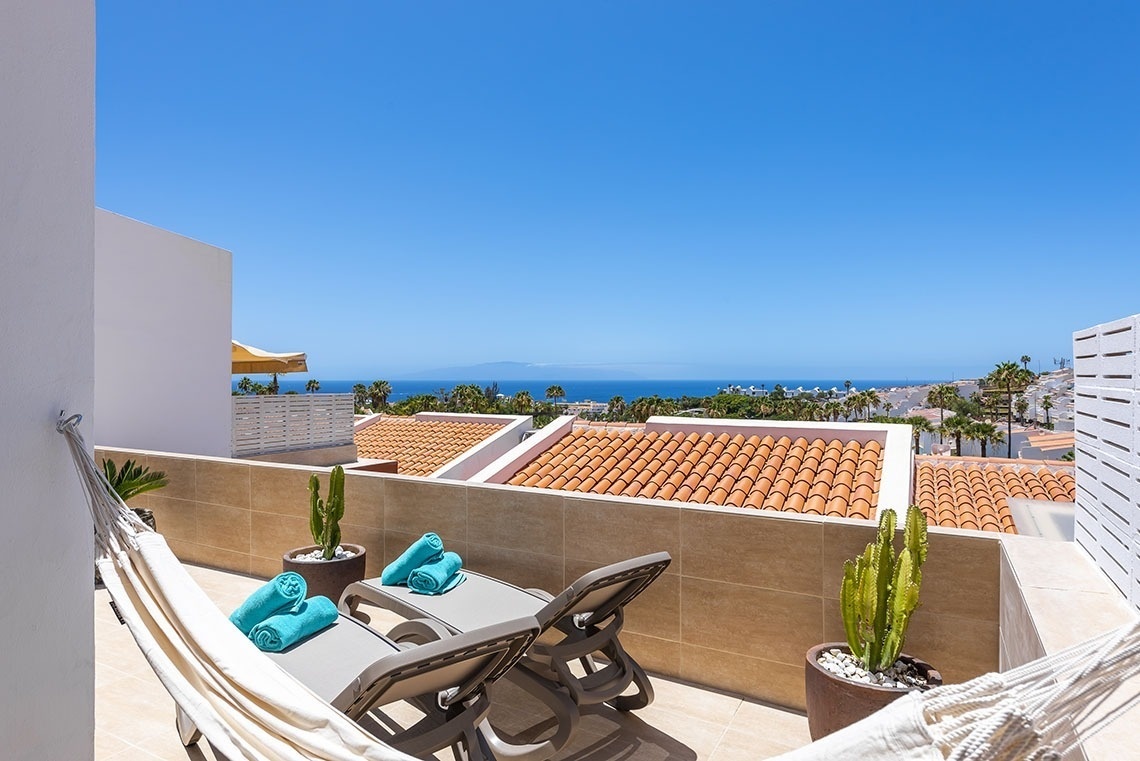 a balcony with a hammock and a view of the ocean