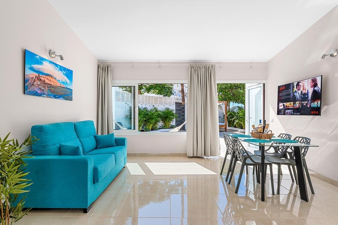 a living room with a blue couch and a netflix tv