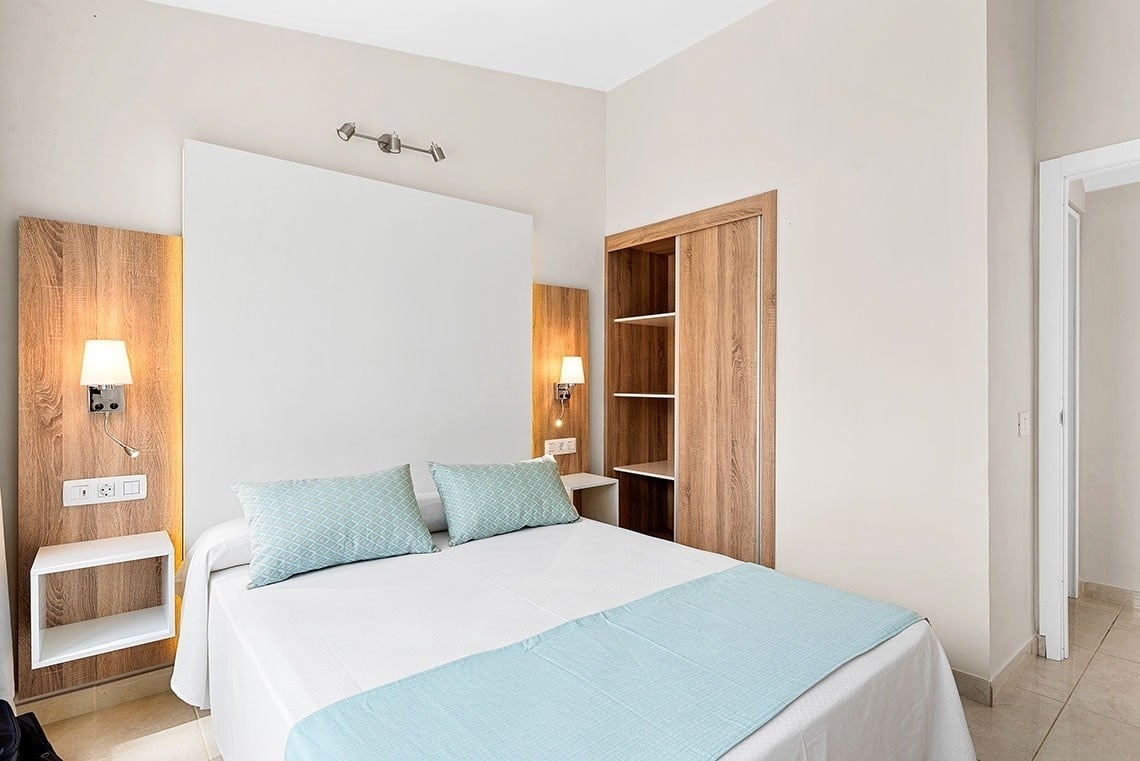 a bedroom with a bed and a mirror on the wall