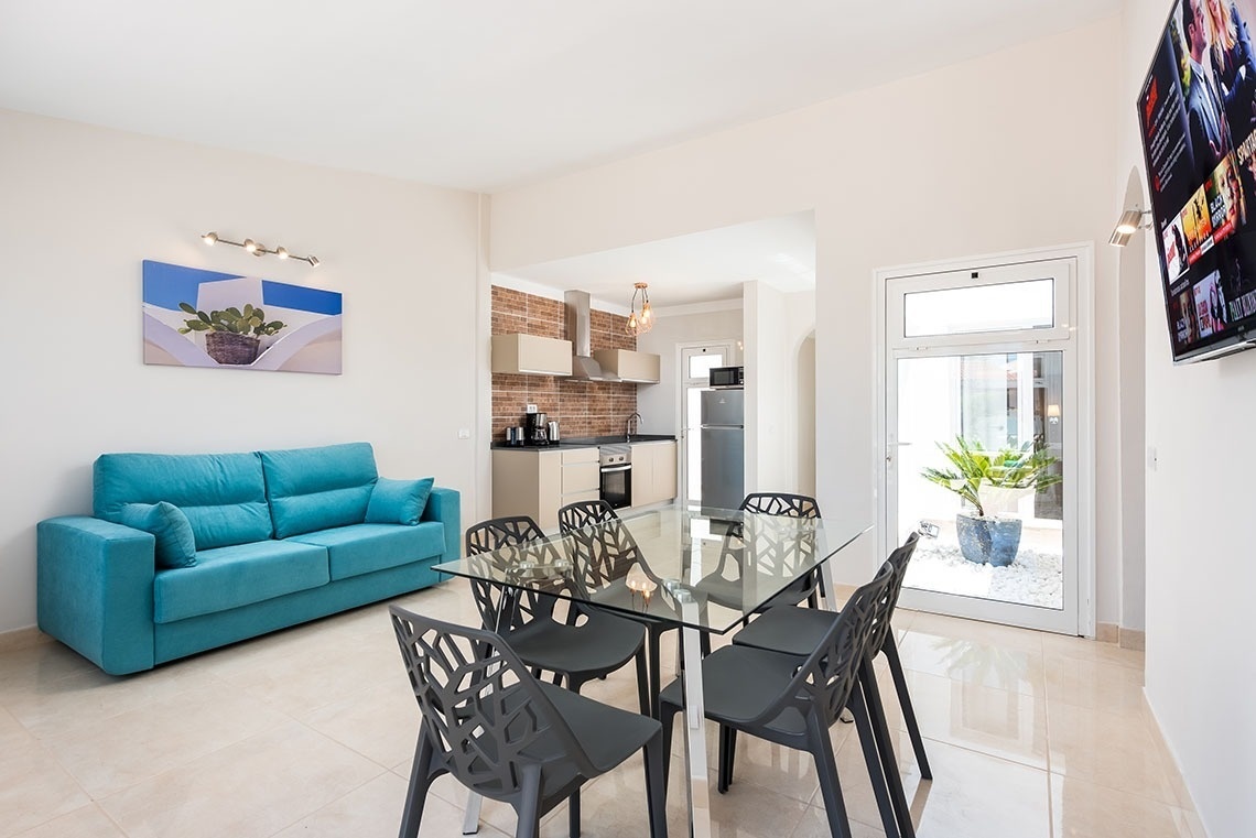 a living room with a blue couch and a glass table
