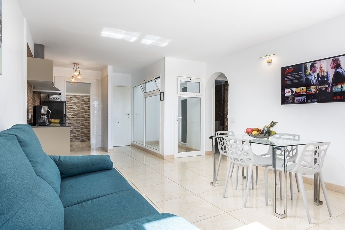 a living room with a blue couch and a netflix sign on the wall