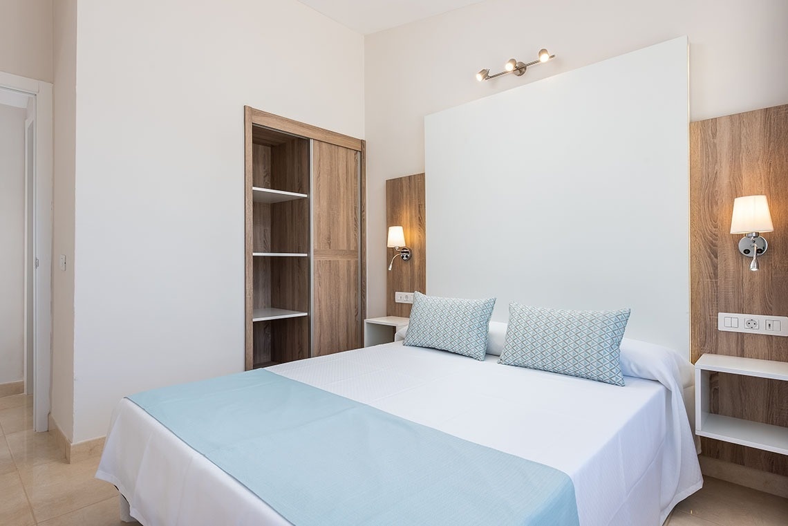 a bedroom with a white bed and blue pillows