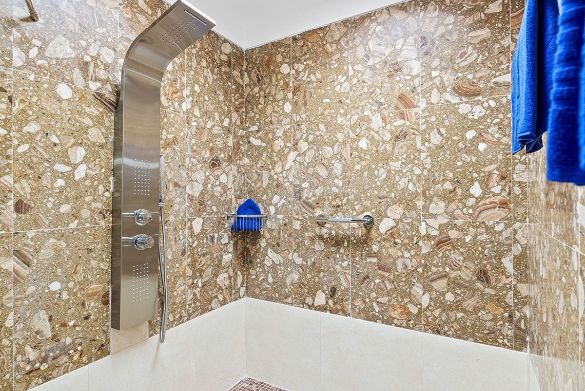 a shower with a blue towel hanging on the wall