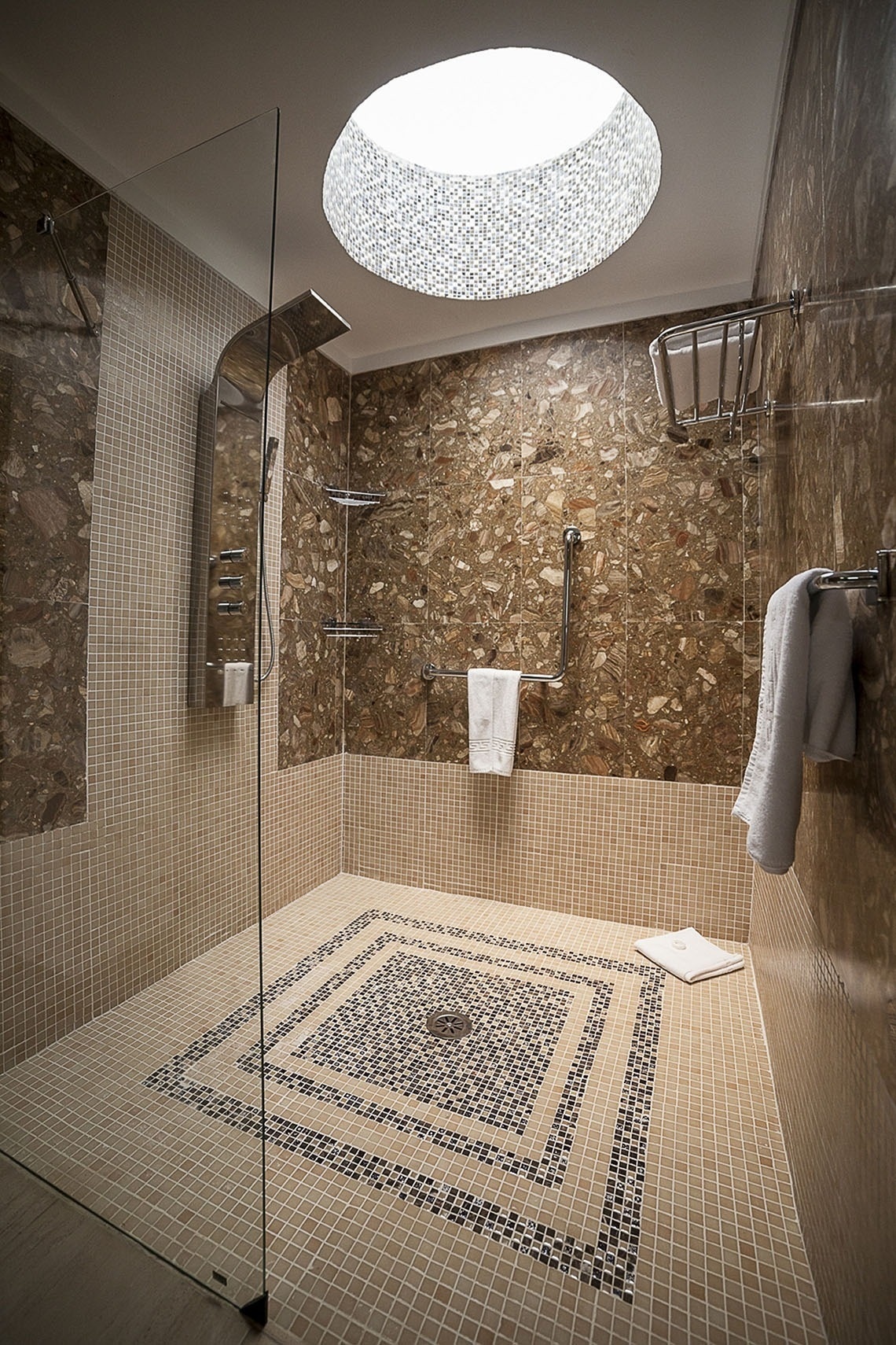 a bathroom with a walk in shower with a mosaic floor