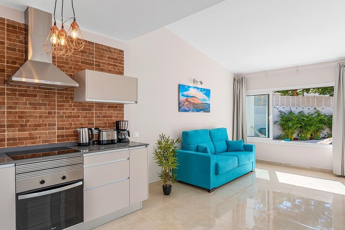 a kitchen with a blue couch and a painting on the wall