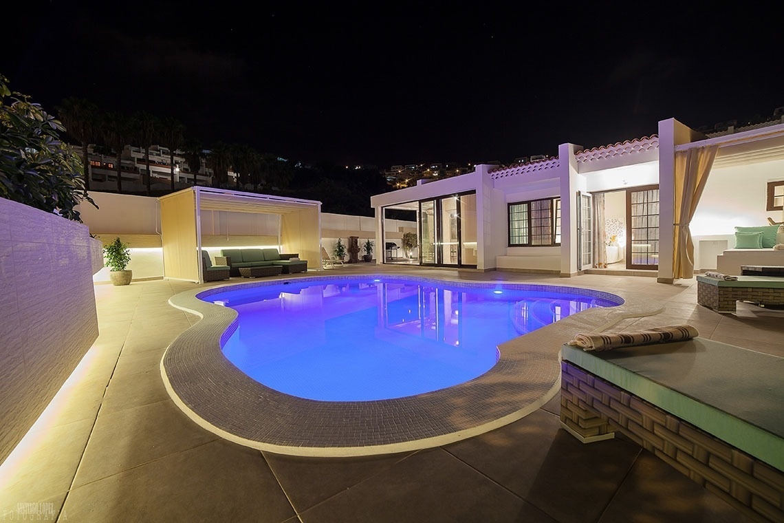 a large swimming pool is lit up at night