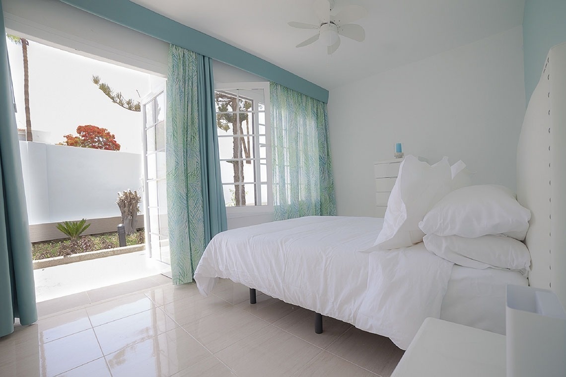 a bedroom with a bed and a ceiling fan
