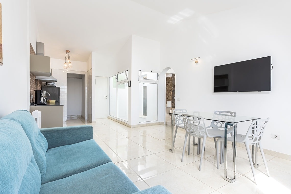 a living room with a blue couch and a flat screen tv