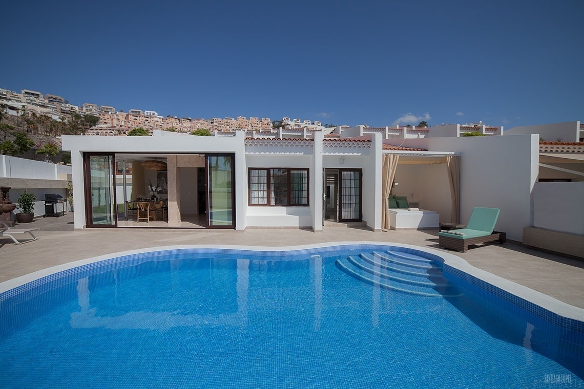 a white house with a swimming pool in front of it