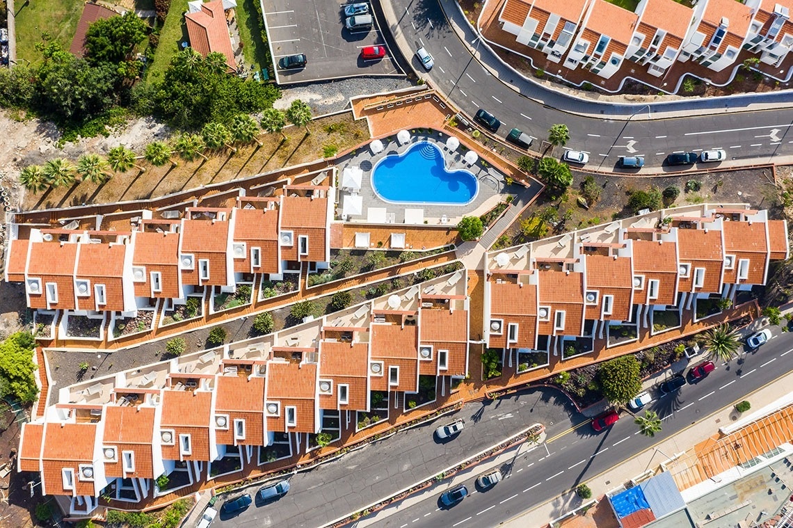 una vista aérea de un complejo de apartamentos con una piscina