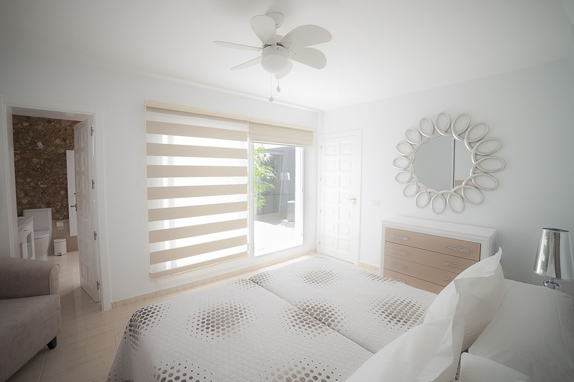 a bedroom with two beds a mirror and a ceiling fan