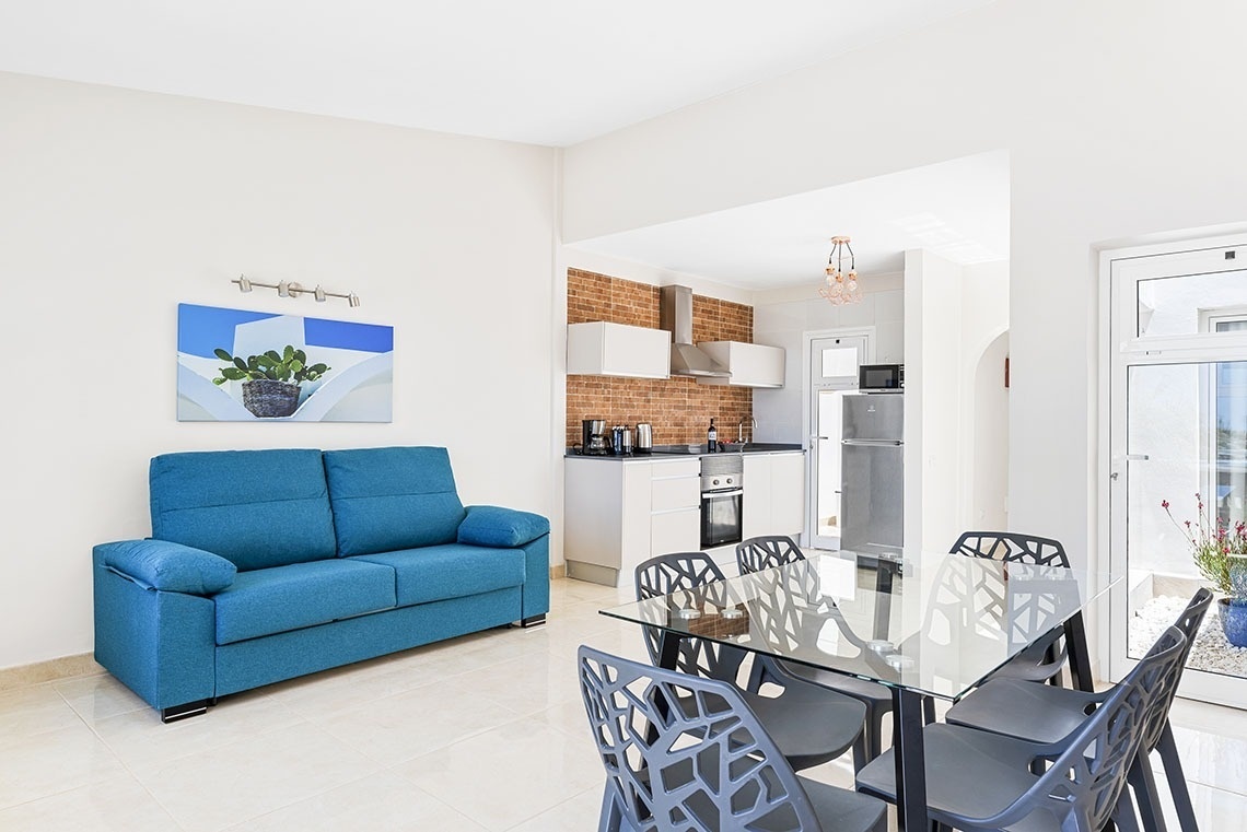 a living room with a blue couch and a glass table