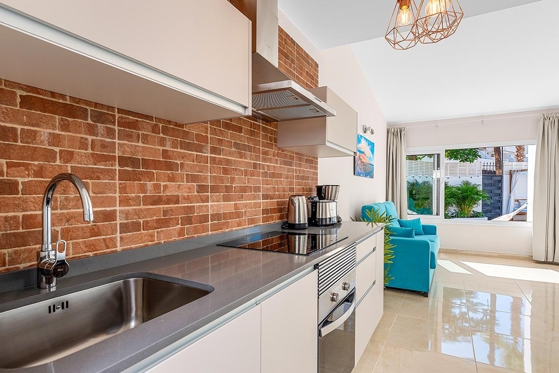 a kitchen with a stainless steel sink and a stove top oven