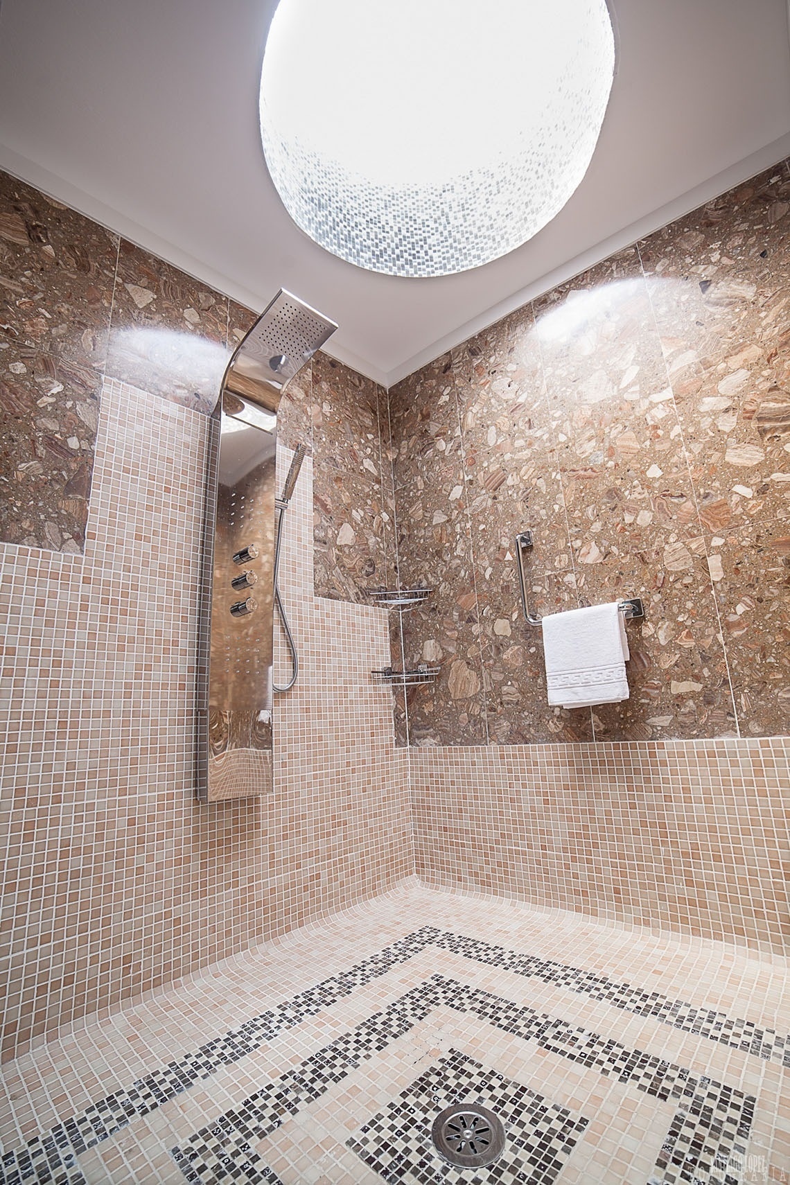a bathroom with a walk in shower and a ceiling light