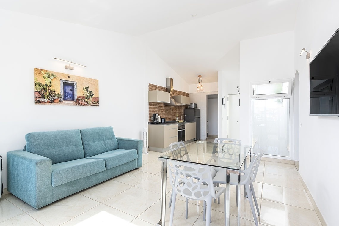 a living room with a blue couch and a glass table