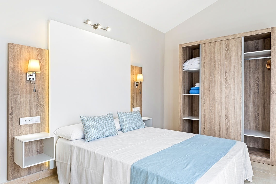 a bedroom with a white bed and blue pillows