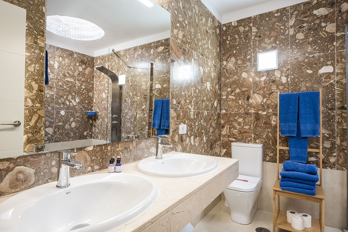 a bathroom with two sinks a toilet and a mirror