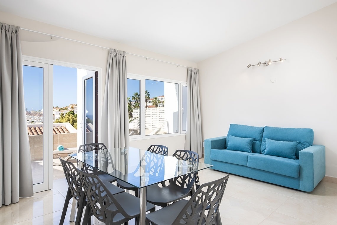 a living room with a blue couch and a glass table