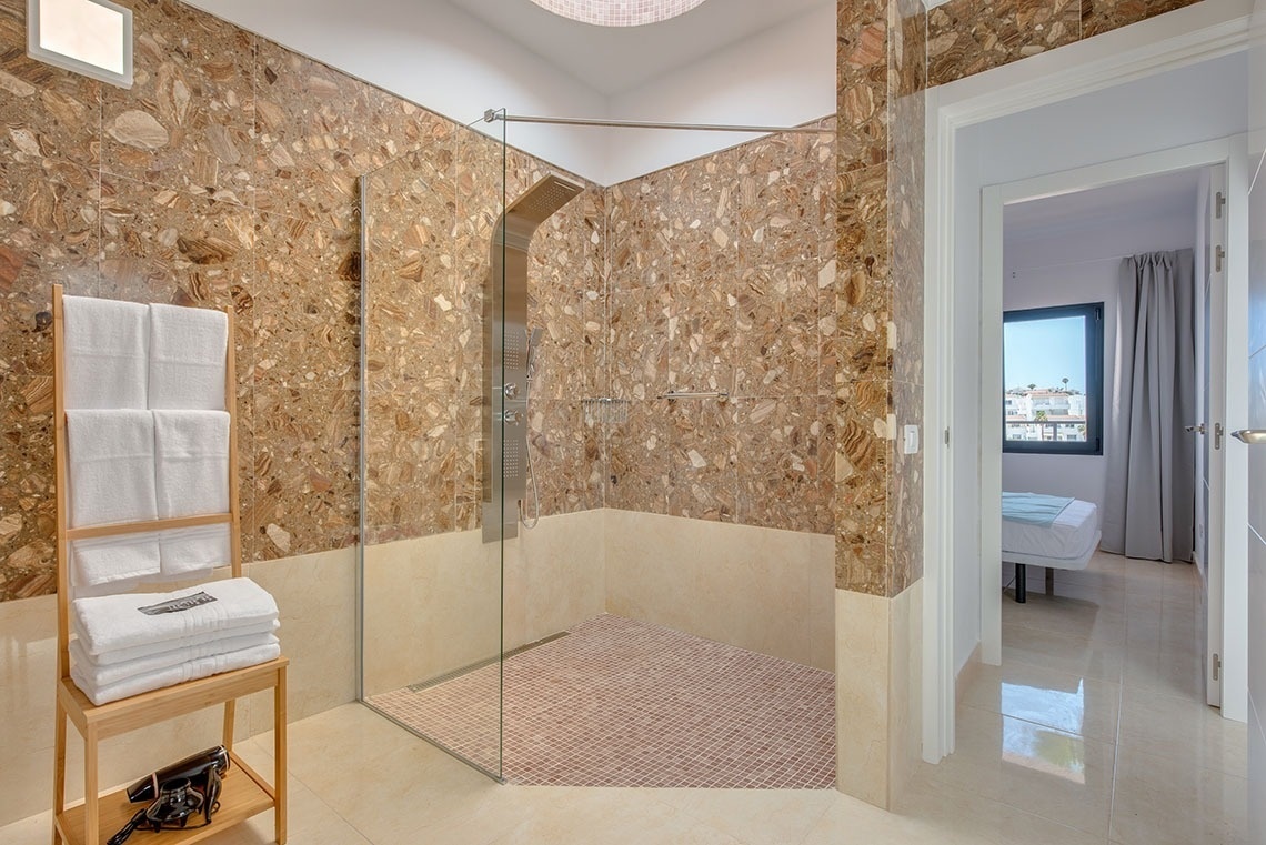 a bathroom with marble walls and a walk in shower