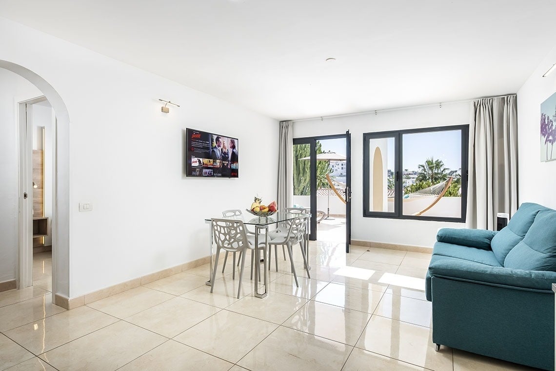 a living room with a blue couch and a tv that says netflix on it