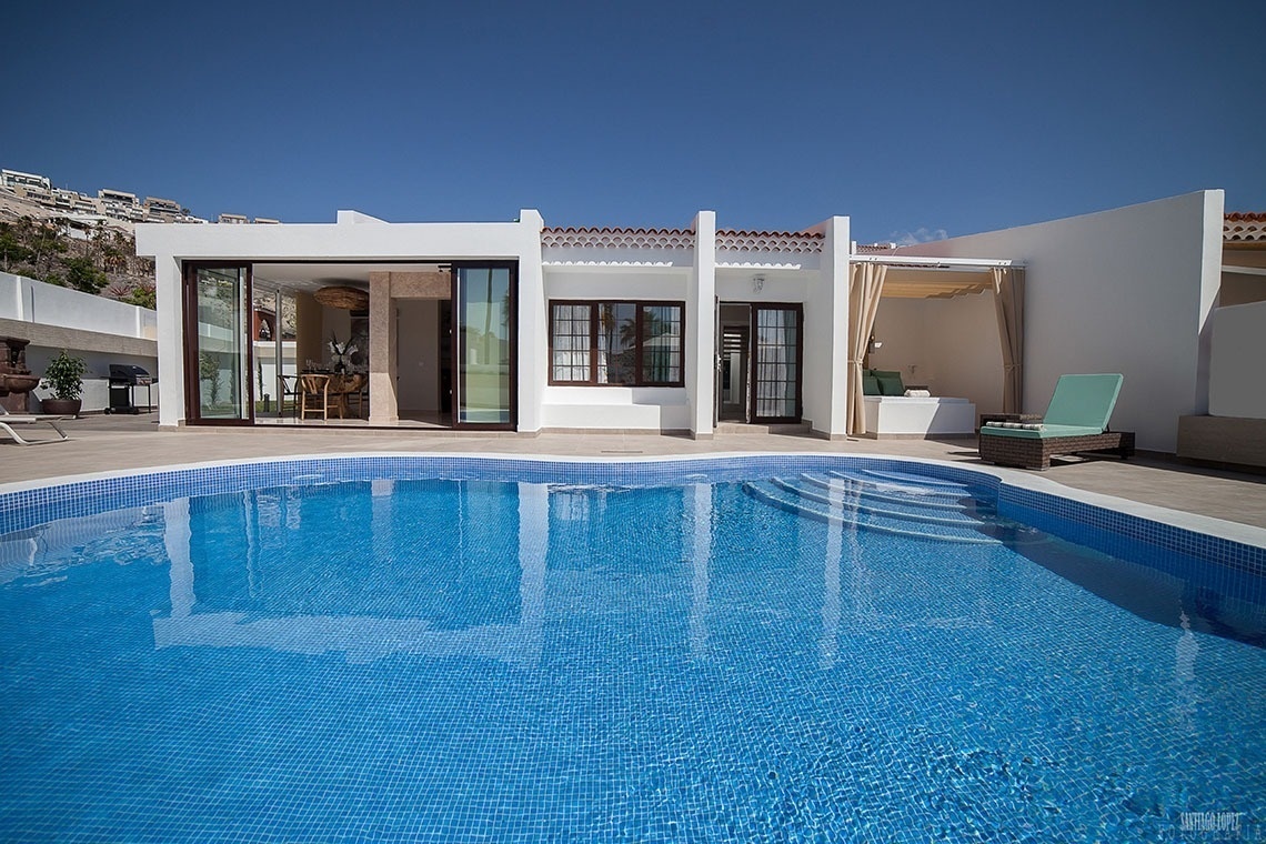 a white house with a swimming pool in front of it